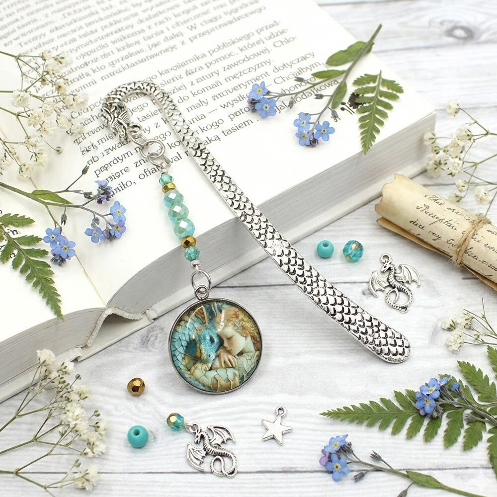 rebrna zakładka do książki z trzonem w kształcie smoka, szklanymi kryształkami oraz zawieszką z grafiką śpiącej księżniczki i smoka