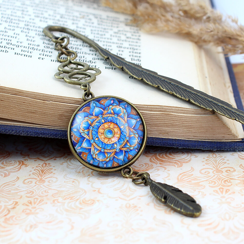 Zakładka do książki z antycznego brązu z wielobarwną mandalą o florystycznym kształcie zamkniętą pod szklanym kaboszonem na tle misternie rzeźbionej zawieszki.
