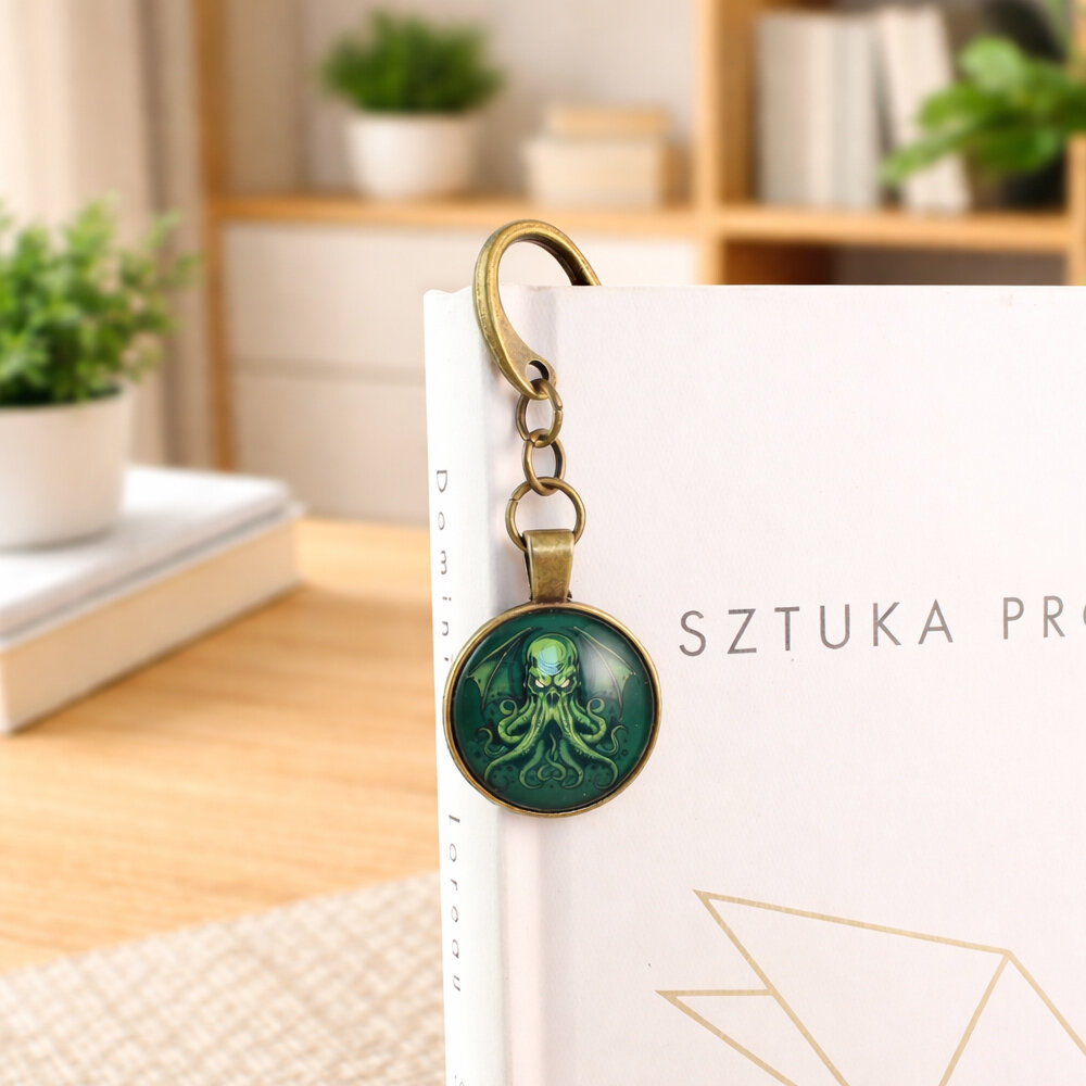 Zakładka do książki z antycznego brązu z graficznym przedstawieniem Przedwiecznego Cthulhu pod szklanym kaboszonem na tle zielonych odcieni.