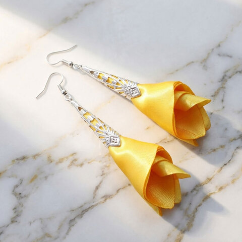 Długie, żółte satynowe kolczyki materiałowe w kształcie kwiatów ze srebrnym ażurowym wykończeniem Długie, żółte satynowe kolczyki materiałowe w kształcie kwiatów ze srebrnym ażurowym wykończeniem