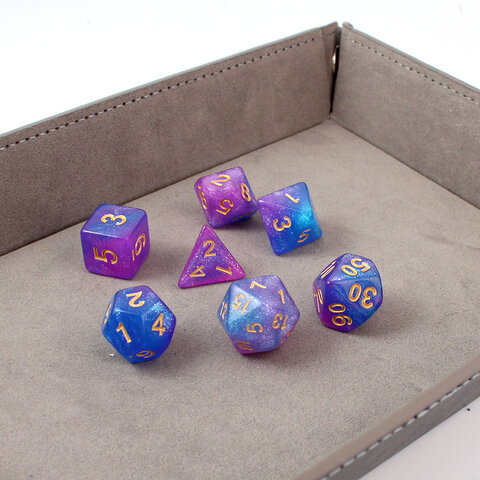 Zestaw brokatowych kości RPG Astro Dust w kolorach niebieskim i fioletowym ze złotymi cyframi. Zestaw brokatowych kości RPG Astro Dust w kolorach niebieskim i fioletowym ze złotymi cyframi.