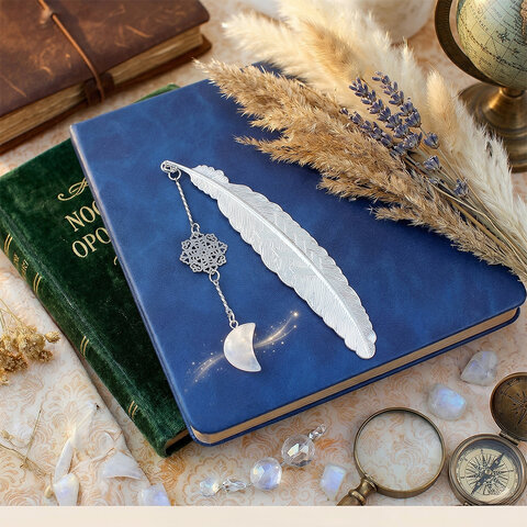 Cienka srebrna zakładka do książki pióro z zawieszką z kryształu górskiego w kształcie księżyca i ażurową rozetką w ozdobnym pudełku. Cienka srebrna zakładka do książki pióro z zawieszką z kryształu górskiego w kształcie księżyca i ażurową rozetką w ozdobnym pudełku.