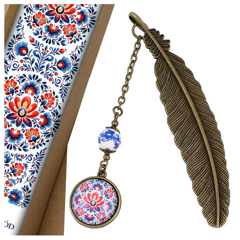 Zakładka do książki z antycznego brązu z ozdobnym, ceramicznym koralikiem i barwnym wzorem ludowych kwiatów pod szklanym kaboszonem.