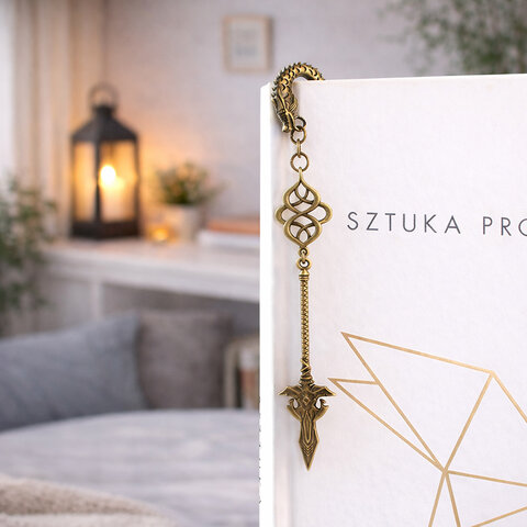 Zakładka do książki z antycznego brązu z motywem łusek smoka i zawieszką w kształcie dużej, zdobionej włóczni w stylu fantasy.