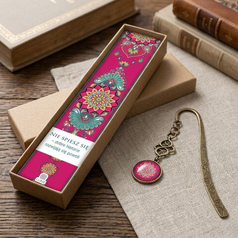 Zakładka do książki z antycznego brązu z niebieskimi koralikami i wielobarwną, harmonijną mandalą pod wypukłym szkiełkiem.