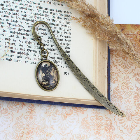 Zakładka do książki z antycznego brązu z owalnym szklanym kaboszonem przedstawiającym mroczny posążek Cthulhu inspirowany prozą Lovecrafta.