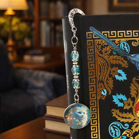 Srebrna zakładka do książki z metalowym trzonem w kwiaty i motyle, niebieskimi koralikami oraz zawieszką z autorską grafiką białego długowłosego kota