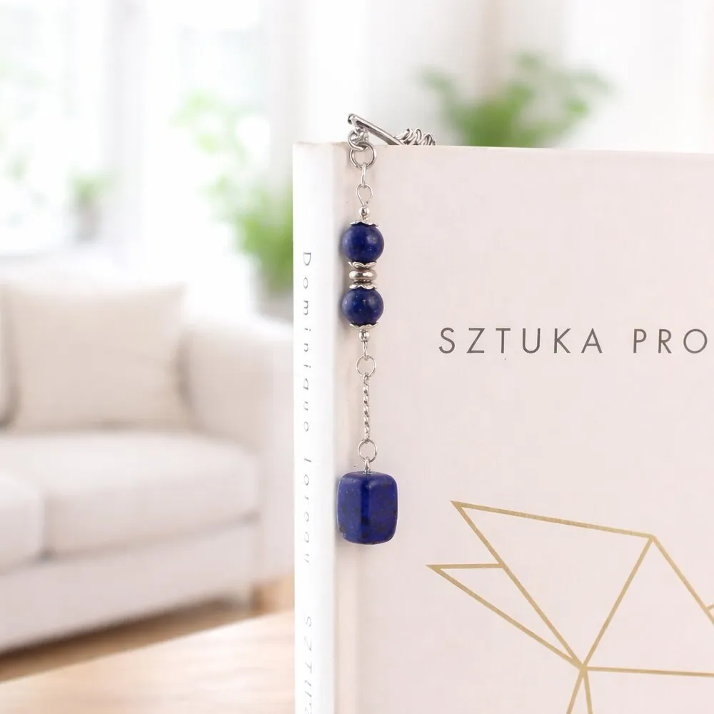 Cienka metalowa zakładka do książki piórko w kolorze grafitowym z zawieszką z granatowego kamienia Lapis Lazuli, w ozdobnym pudełku.