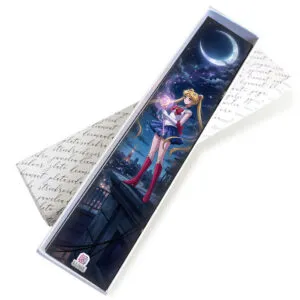 Metalowa zakładka do książki w kolorze antycznego srebra z grafiką Czarodziejki z Księżyca (Sailor Moon) pod szklanym kaboszonem, ozdobiona niebiesko-fioletowymi koralikami i gwiazdką.