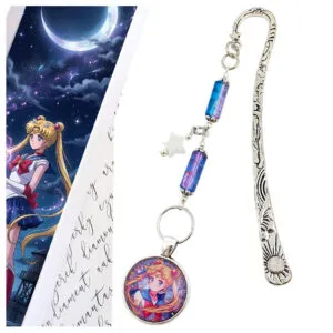 Metalowa zakładka do książki w kolorze antycznego srebra z grafiką Czarodziejki z Księżyca (Sailor Moon) pod szklanym kaboszonem, ozdobiona niebiesko-fioletowymi koralikami i gwiazdką.