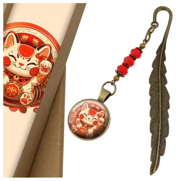 Zakładka do książki z antycznego brązu w kształcie pióra, z czerwonymi kryształkami i grafiką radosnego kota Maneki Neko pod szklanym kaboszonem
