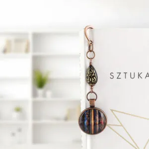 Zakładka do książki z ilustracją starych książek i ozdobnym koralikiem