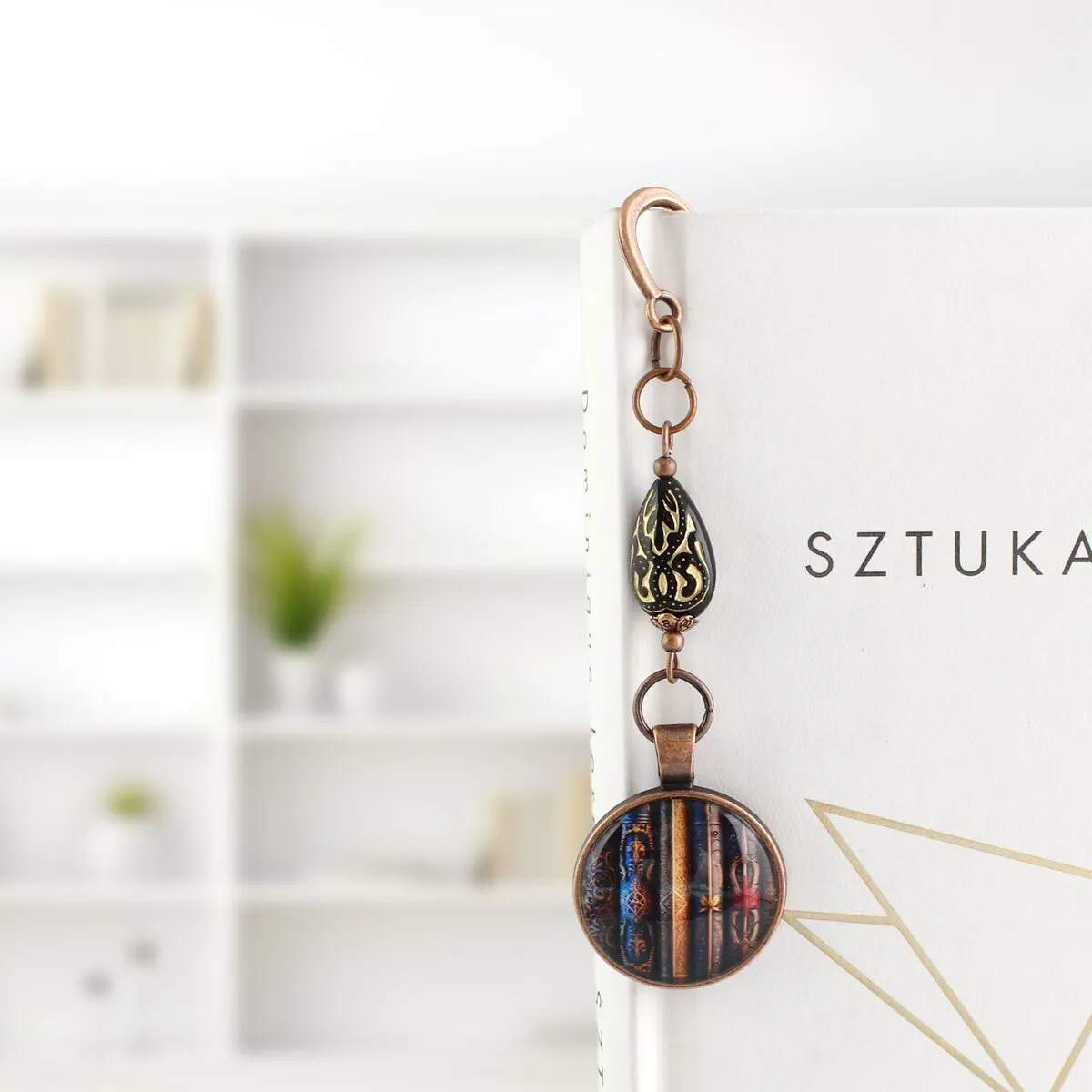 Zakładka do książki z ilustracją starych książek i ozdobnym koralikiem