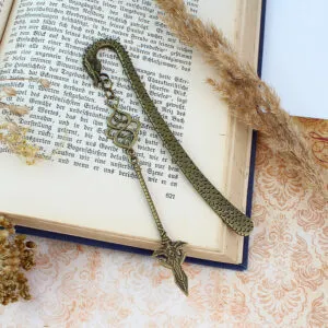 Zakładka do książki z antycznego brązu z motywem łusek smoka i zawieszką w kształcie dużej, zdobionej włóczni w stylu fantasy.